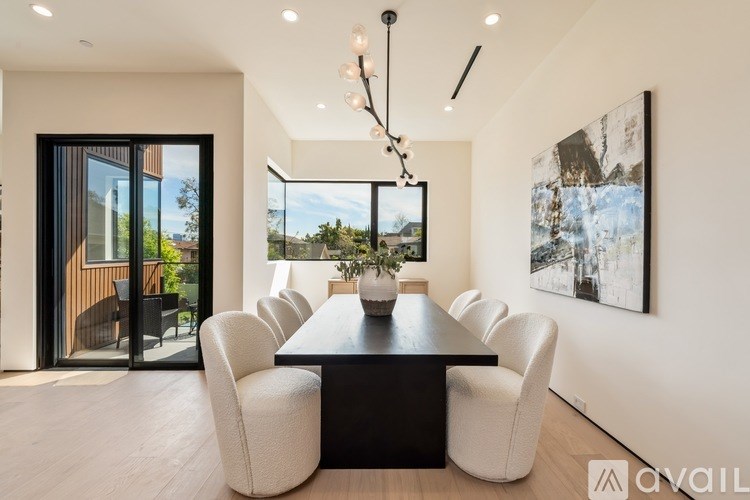 A modern dining room with a large table and chairs.