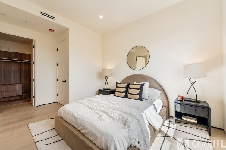 A bedroom with a large bed and a mirror on the wall.