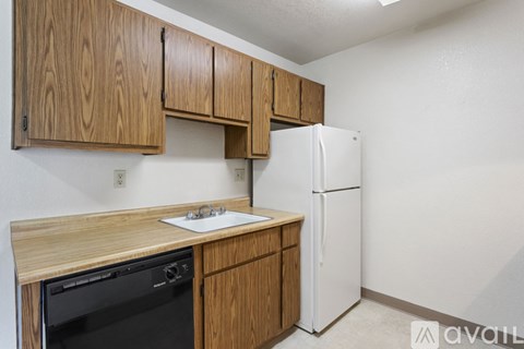 A kitchen with wooden cabinets and a white refrigerator.