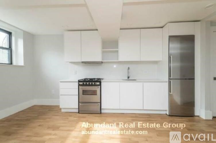 A kitchen with white cabinets and a stainless steel refrigerator.