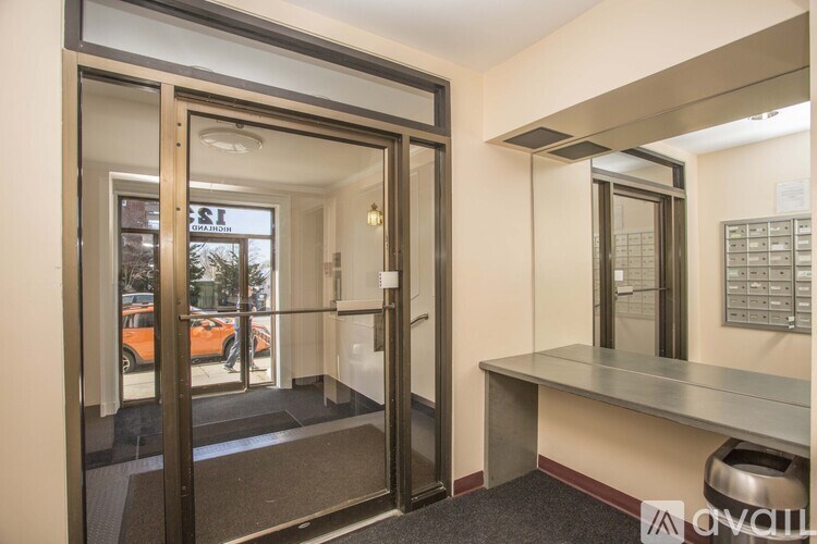 A room with a desk and a window with a view of a street.