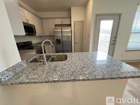 A kitchen with granite countertops and stainless steel appliances.