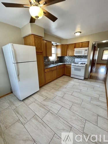 A kitchen with a white fridge and wooden cabinets.