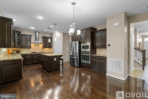 A spacious kitchen with dark wood cabinets and a central island.