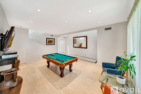 A room with a pool table and a painting on the wall.