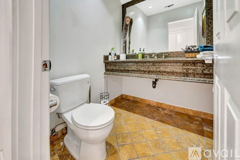 A white toilet in a bathroom with a tiled floor.