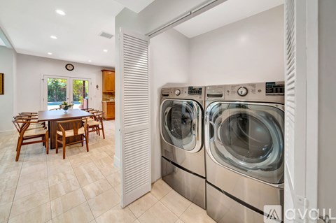 A modern laundry room with a washer and dryer stacked on top of each other.