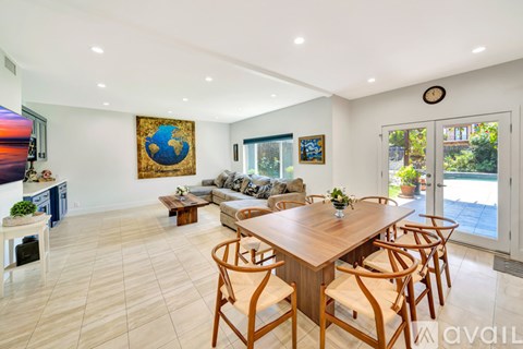 A modern dining room with a wooden table and chairs.