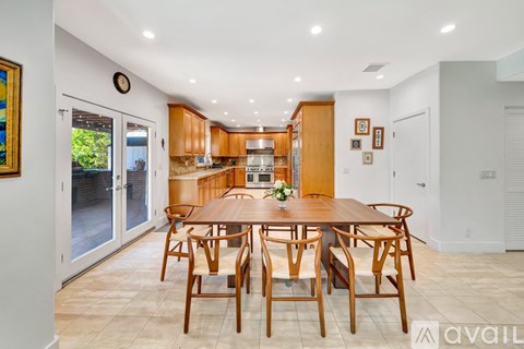 A dining room with a wooden table and chairs.