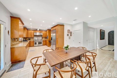 A modern kitchen with wooden cabinets and a dining table set for four.