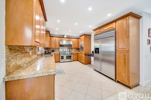 A kitchen with wooden cabinets and a marble countertop.