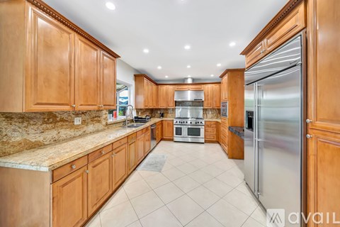 A kitchen with wooden cabinets and a marble countertop.