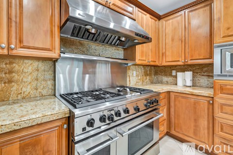 A kitchen with wooden cabinets and a stainless steel range hood.