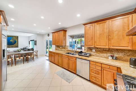 A kitchen with wooden cabinets and a dining table.