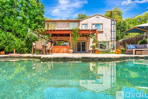 A house with a pool in front of it.