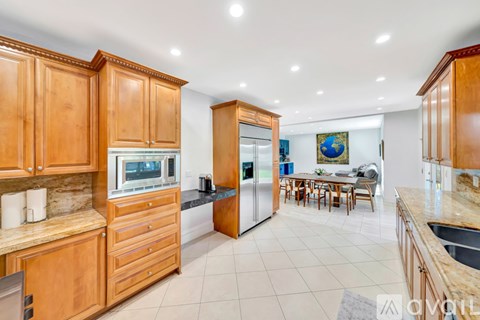 A kitchen with wooden cabinets and a dining table.