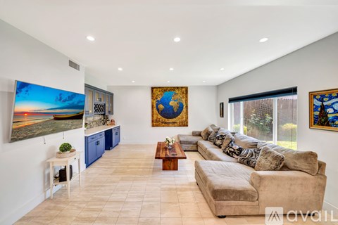 A living room with a couch, a coffee table, and a painting on the wall.