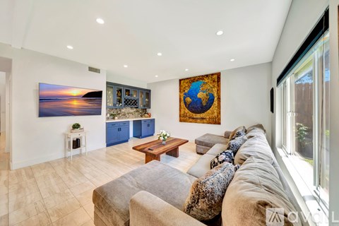 A living room with a couch, a coffee table, and two paintings on the wall.