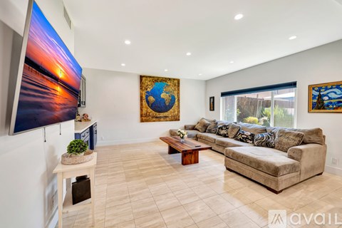 A living room with a large screen TV and a couch.
