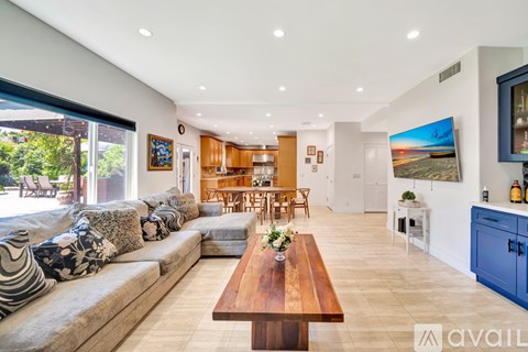A modern living room with a wooden coffee table and a large sofa.