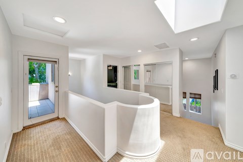 A white interior space with a skylight and a carpeted floor.