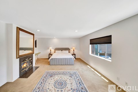 A bedroom with a fireplace and a bed.