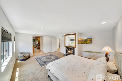 A bedroom with a large bed and a painting on the wall.