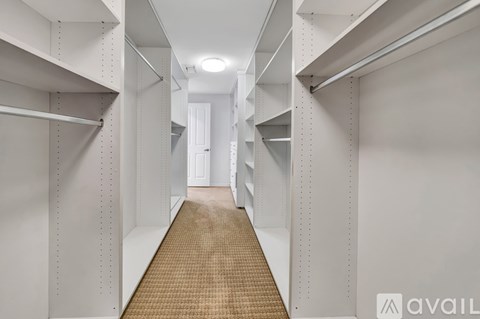 A long hallway with white walls and shelves on the side.