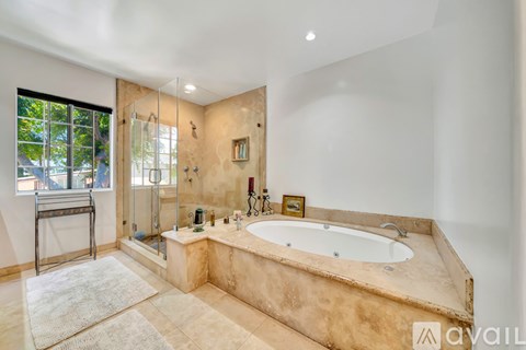 A bathroom with a large tub and a window.