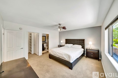 A bedroom with a large bed and a ceiling fan.