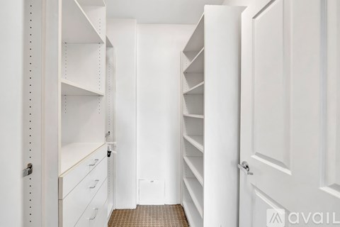 A white walk-in closet with shelves and drawers.
