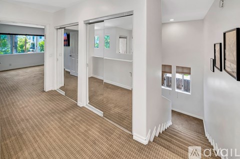 A spacious room with a carpeted floor and white walls.