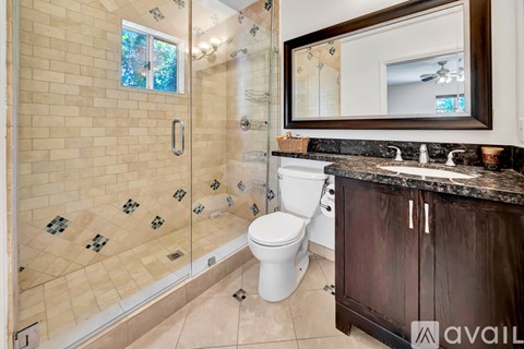 A bathroom with a toilet, a sink, and a walk-in shower.