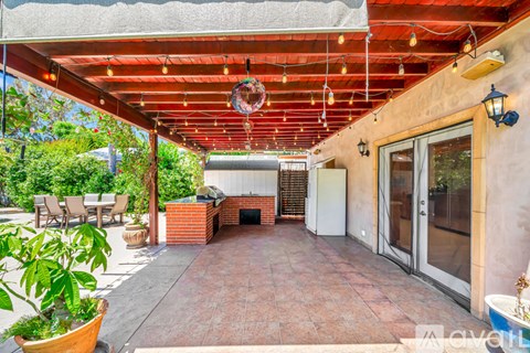 A patio with a red roof and a table and chairs.
