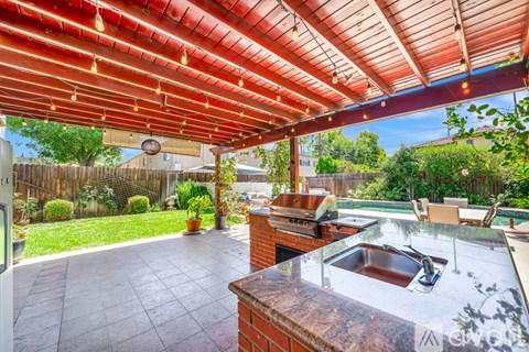 A patio with a red roof and a brick counter.