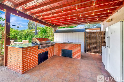 A patio with a brick oven and a grill.