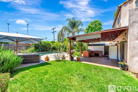 A backyard with a patio and a pool.