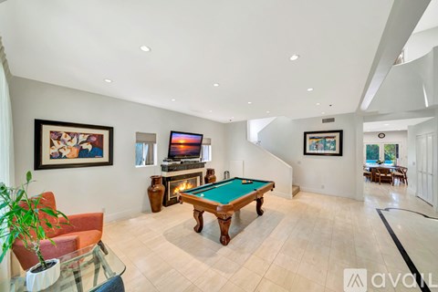 A room with a pool table and a fireplace.