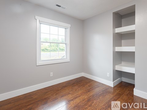A room with a window and a shelf.