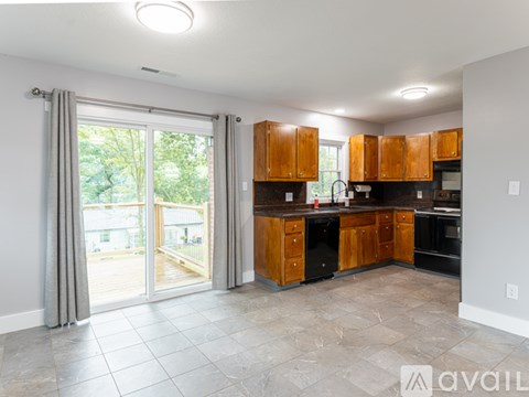 A kitchen with wooden cabinets and black appliances.