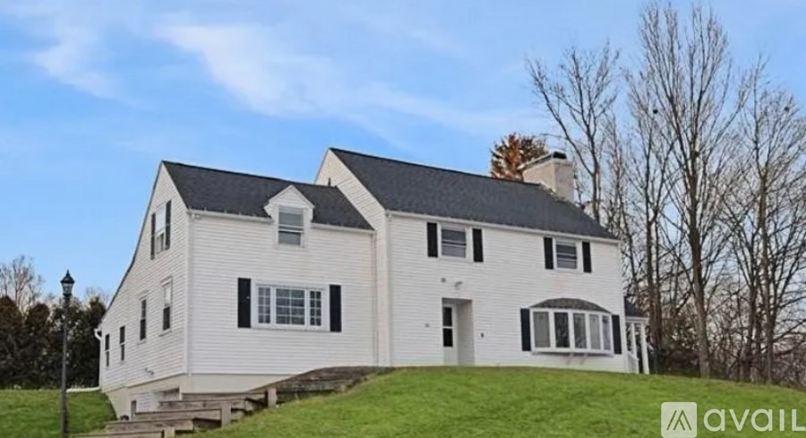 A white house with black shutters is for sale.