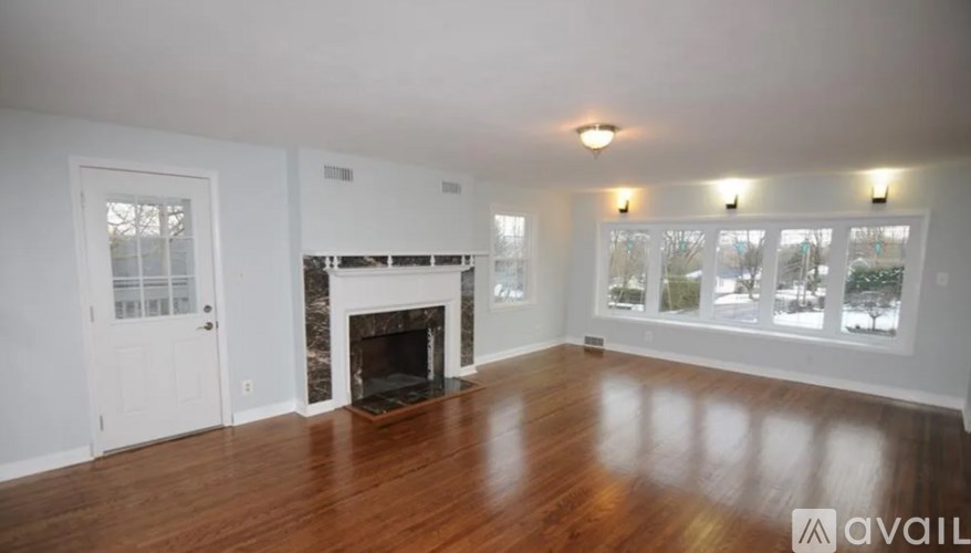 A spacious living room with a fireplace and wood flooring.