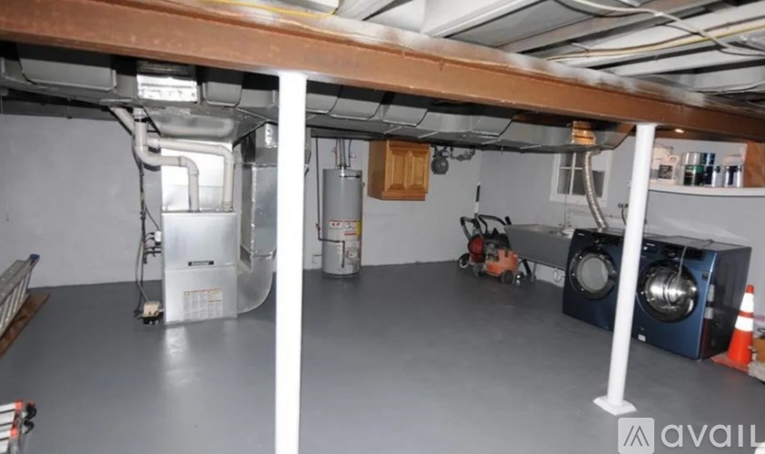 A room with a white ceiling and a grey floor with a white pipe running along the wall.