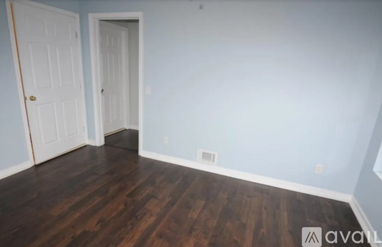 A room with two doors and wooden floors.