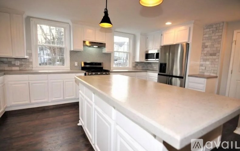 A kitchen with white cabinets and a large island.