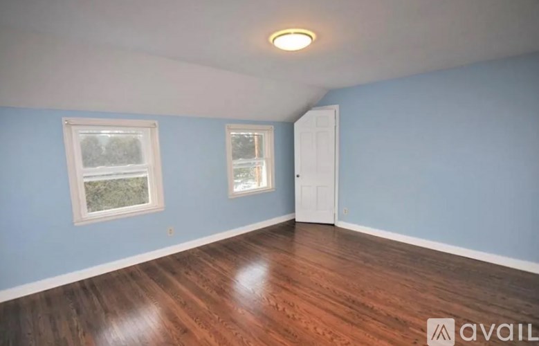 A room with wooden floors and two windows.