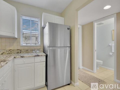 A kitchen with a stainless steel refrigerator and cabinets.