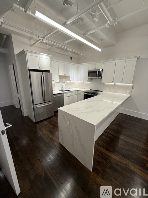 A kitchen with white cabinets and a white island.
