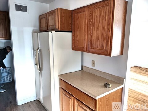 A kitchen with wooden cabinets and a white fridge.