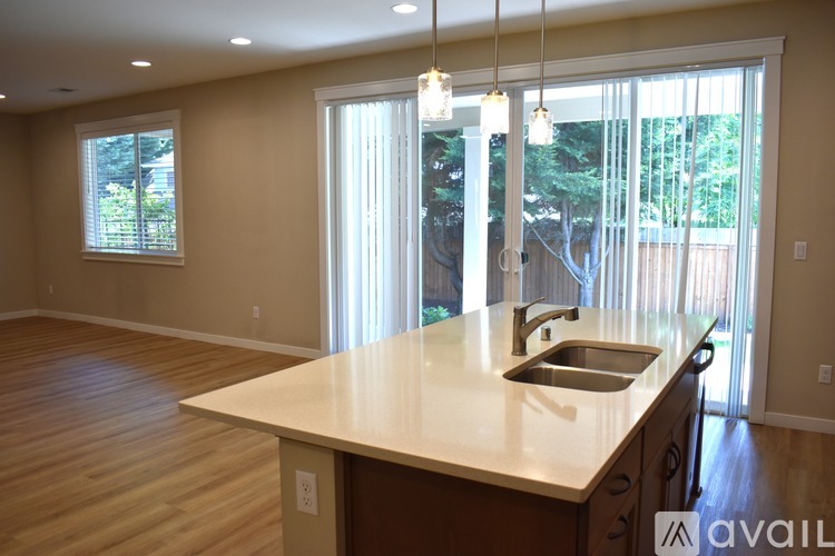 A kitchen with a wooden floor and a counter with a sink.